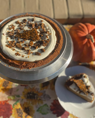 Miso Pumpkin Pie on a cake stand surrounded by fall decor
