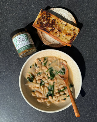 Bowl of brothy beans, plate with toasted bread and a jar of Shared Cultures Morel Mushroom Miso