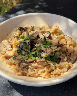 Bowl of risotto topped with mushrooms