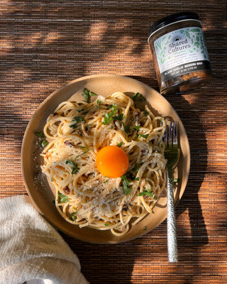 Bowl of miso pasta and a jar of Shared Cultures Black Garlic Miso in the corner