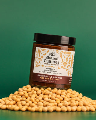 Jar of 'Shared Cultures' Hatcho-Style Soy Miso sitting on top of soybeans