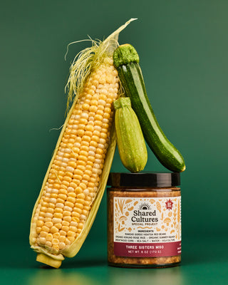 Jar of 'Shared Cultures' Three Sisters Miso with corn and squash stacked around the jar