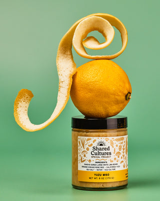 Jar of 'Shared Cultures' Yuzu Miso with a yuzu and yuzu zest placed above the jar
